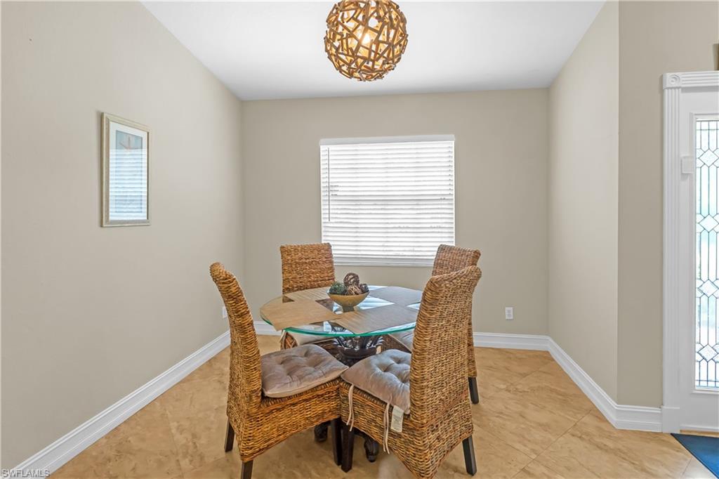 Recessed dining area featuring tile flooring, a single window with blinds, and a decorative orb pendant light