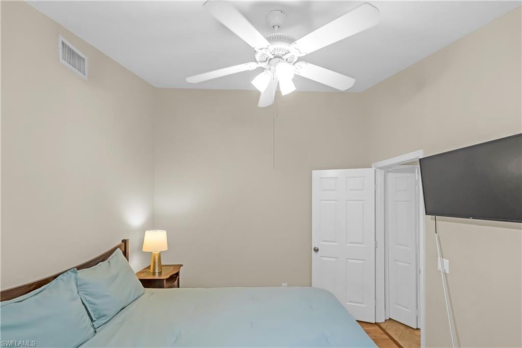 Ceiling fan with integrated lighting, natural wood-finish flooring, and white paneled doors