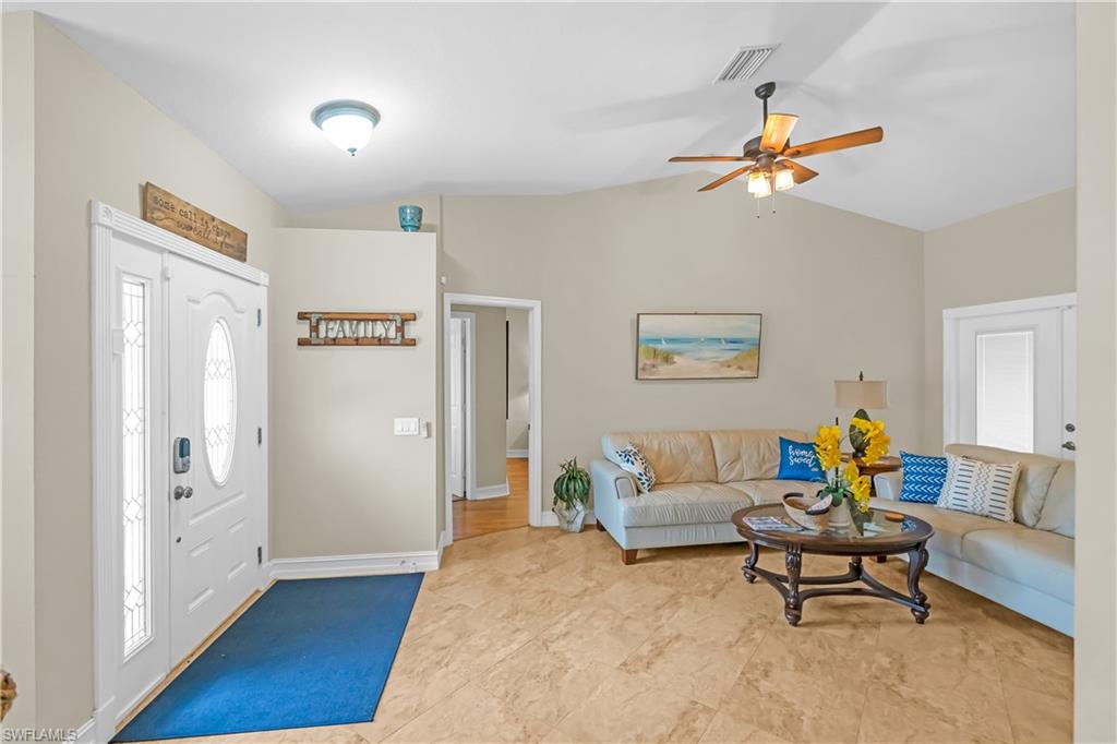 Bright, open living area showcasing wood-finish flooring throughout, recessed ceiling lighting, and a ceiling fan with integrated light fixture