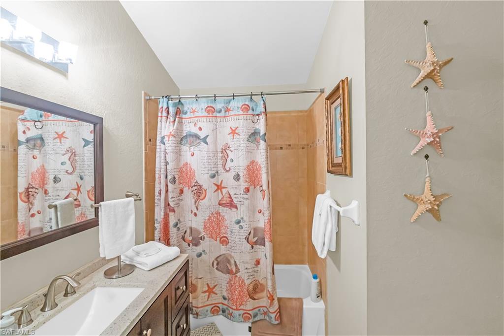 Vanity with a single basin sink, brushed nickel faucet, and composite countertop