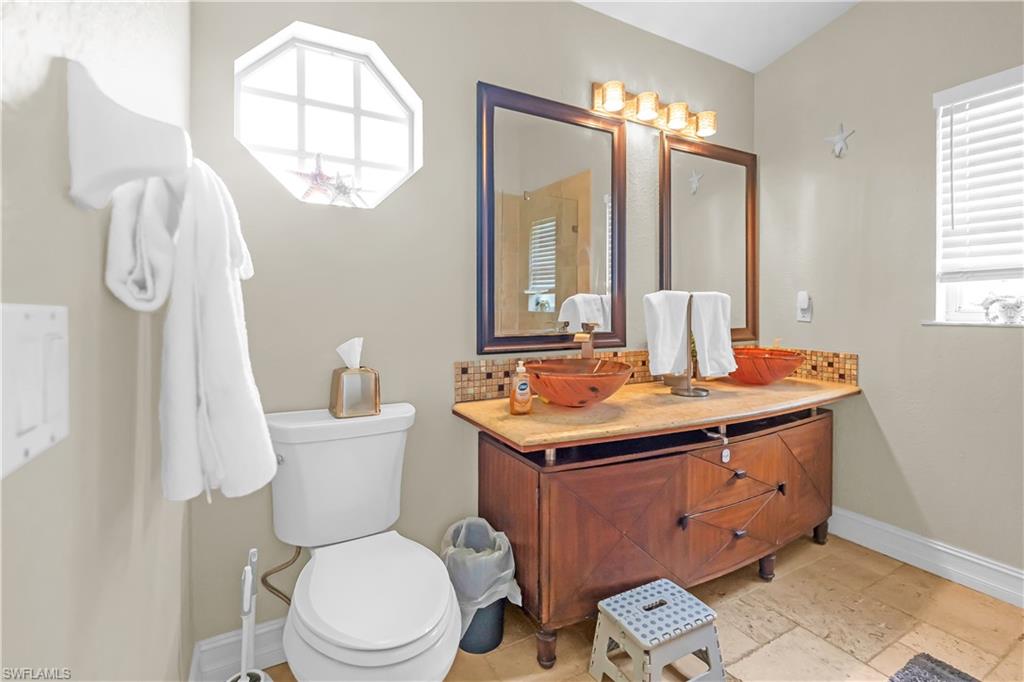 Dual vessel sinks with an integrated vanity cabinet, complemented by a tiled backsplash