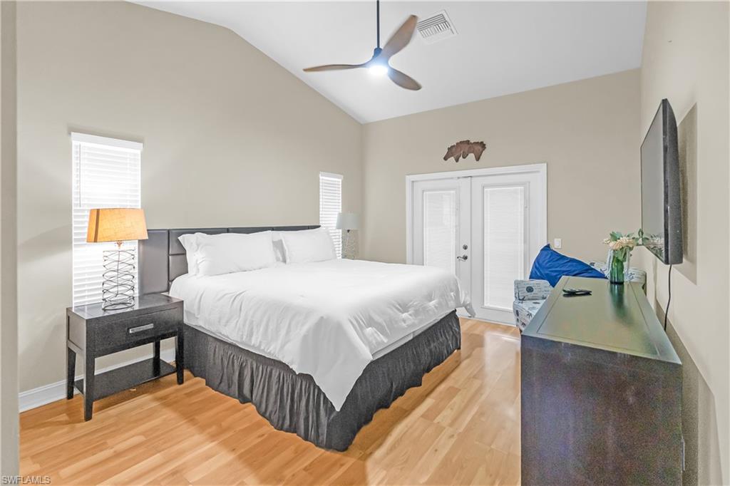 Vaulted ceilings, wood-finish flooring, ceiling fan, and French doors