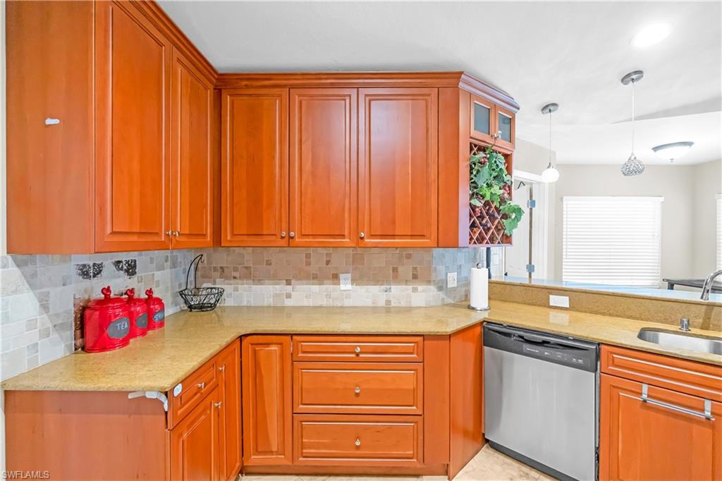 Wood cabinetry with crown molding, light-toned countertops, and a mosaic tile backsplash
