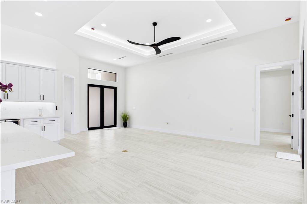 OPEN LIVING AREA showcases a dramatic DOUBLE-TRAY CEILING w/ LED ACCENT LIGHTING, sleek LINEAR A/C DIFFUSERS & contemporary statement ceiling fan.