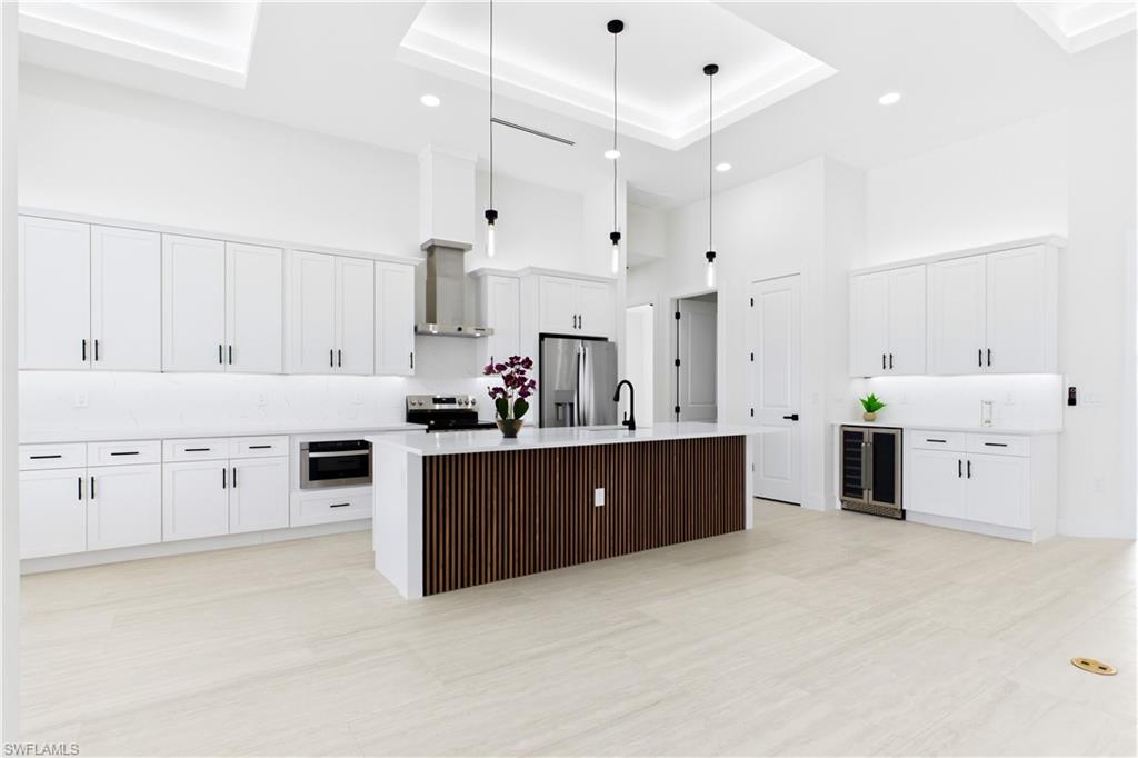 STUNNING CHEF’S KITCHEN w/ sophisticated CUSTOM CABINETRY w/ crisp WHITE SHAKER CABINETRY.