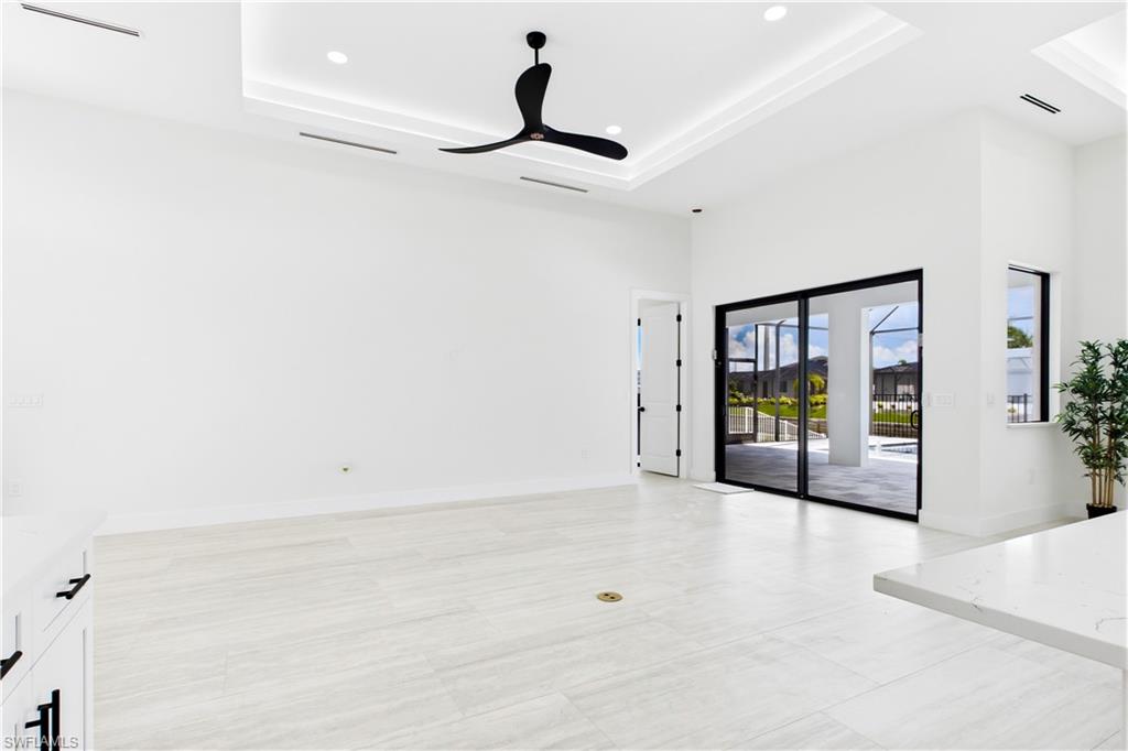 BRIGHT OPEN LIVING AREA w/ soaring VOLUME CEILINGS, dramatic LED-LIT TRAY DETAIL & OVERSIZED SLIDING GLASS DOORS seamlessly connecting to POOL & LANAI.