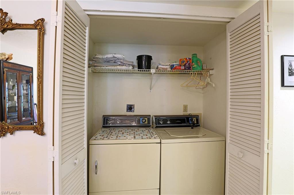 Laundry closet with louvered bi-fold doors, upper wire shelving, and appliance hookups