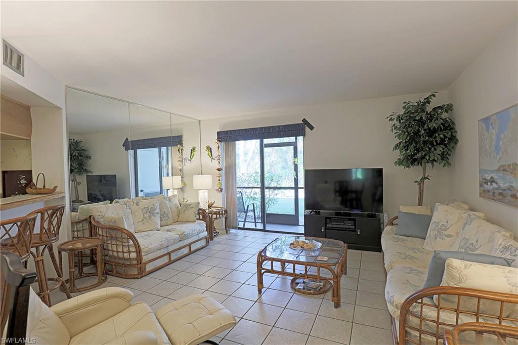 Tiled flooring throughout, mirrored wall panels, and sliding glass doors to outdoor space