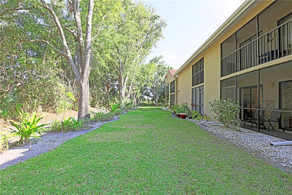 Expansive green space with mature trees and a gravel border