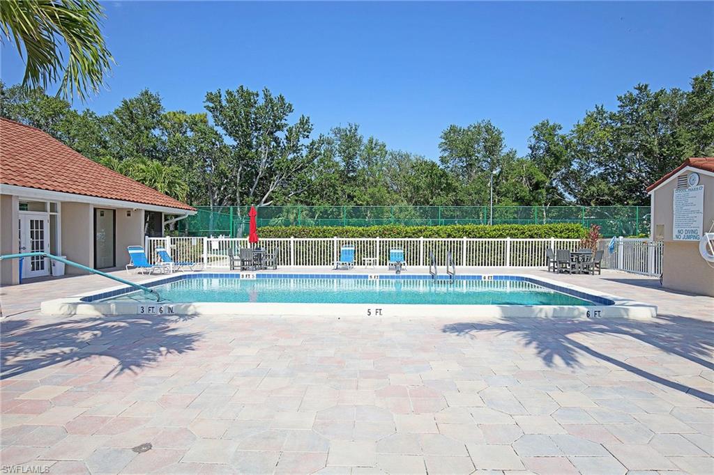 Swimming pool with a tile border and handrail, surrounded by a paver patio