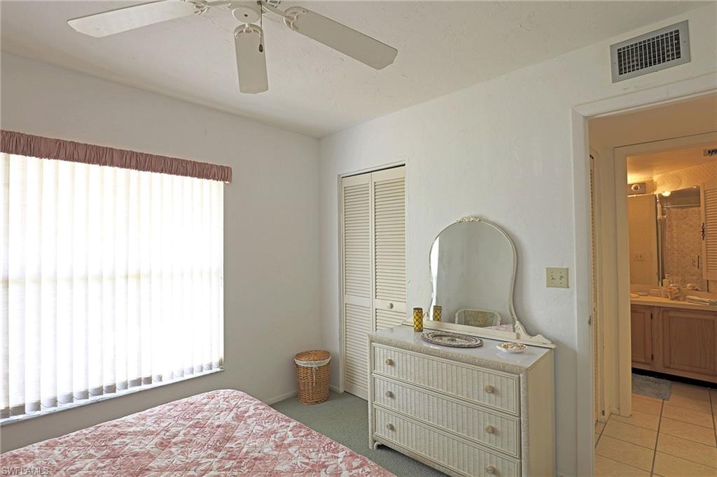 Room featuring a ceiling fan, window with vertical blinds, and bifold closet doors