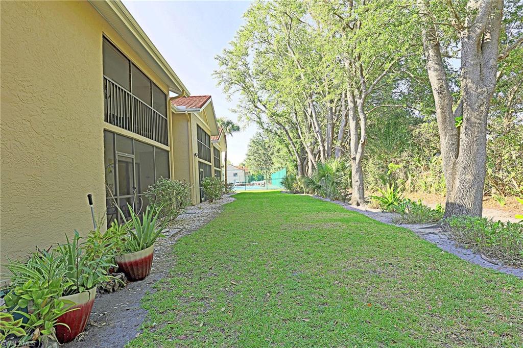 Manicured lawn area bordered by mature trees and shrubs