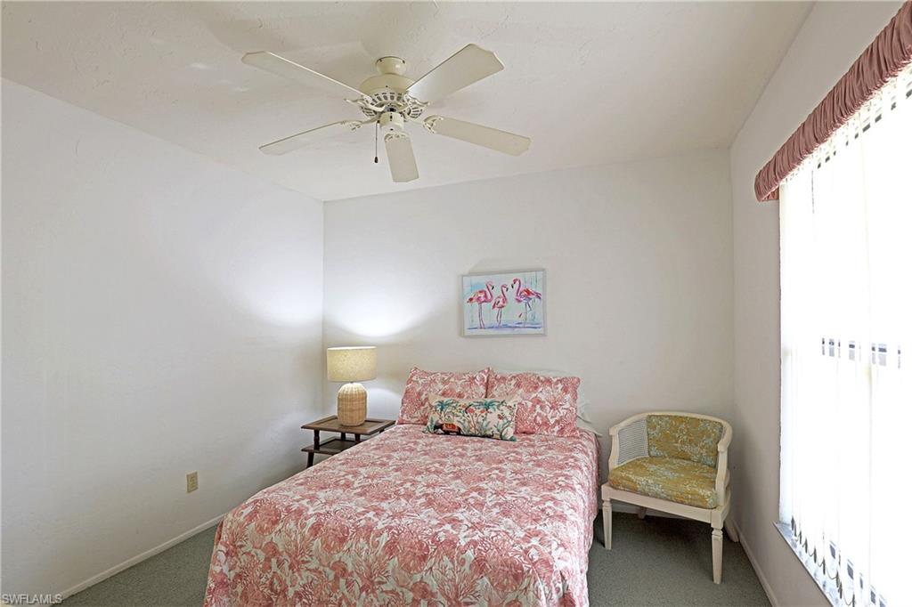 White ceiling fan, white walls, and a window with vertical blinds