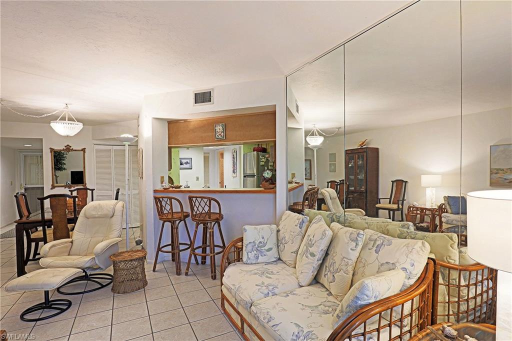 Tiled flooring throughout, mirrored wall panels, and a built-in breakfast bar with overhead lighting