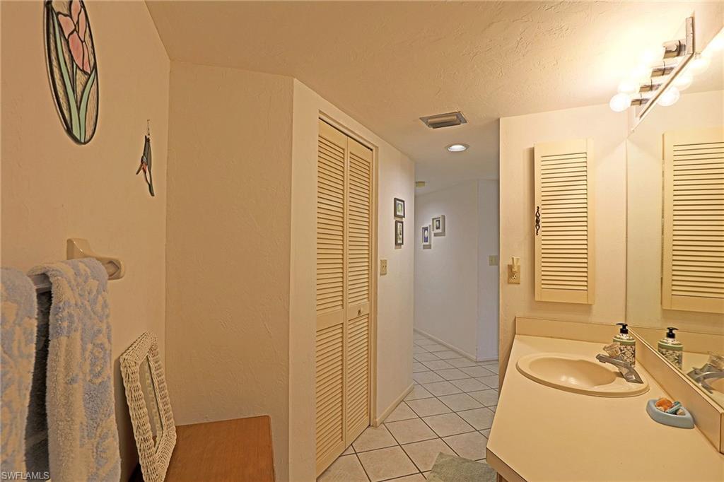 Vanity with integrated sink, full-width mirror, and overhead strip lighting