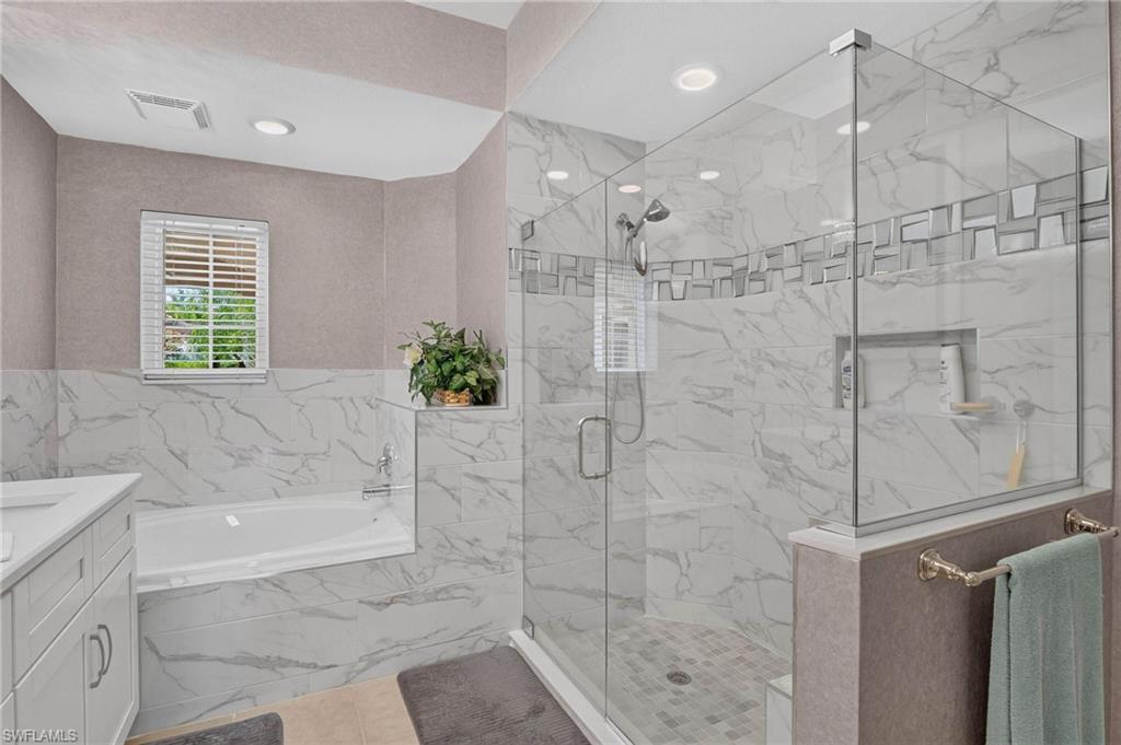 Primary bath with Large soaking tub and expansive glass-enclosed shower with a decorative tile