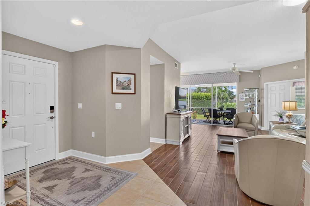View from front entry to back to screened lanaiRecessed ceiling lighting, wood-finish flooring, screened patio, sliding glass doors, and a ceiling fan