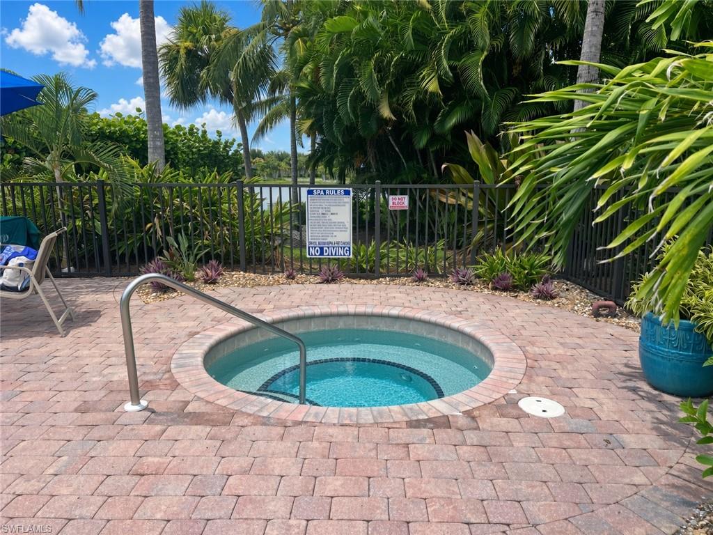 Circular spa with integrated grab rail, surrounded by brick paver decking