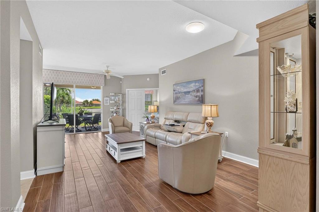 Rich wood-finish flooring throughout, featuring a vaulted ceiling and a ceiling fan