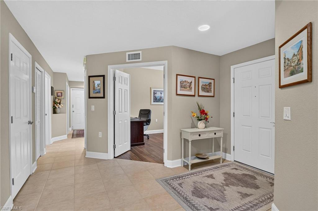 Foyer with tile flooring, recessed lighting, and a paneled entry door