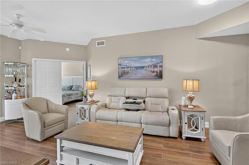 Vaulted ceiling, wood-finish flooring, recessed lighting, ceiling fan, and white doors to Primary bedroom