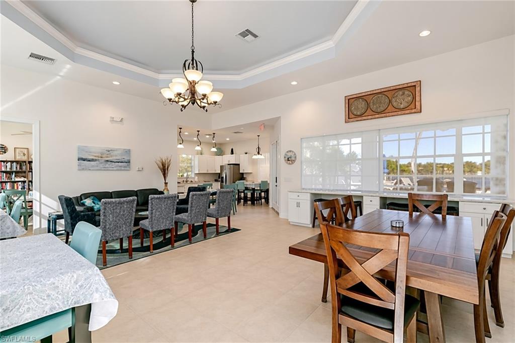 View of Clubhouse common areas. Open-concept living area with tray ceiling, recessed lighting, large windows, and built-in cabinetry