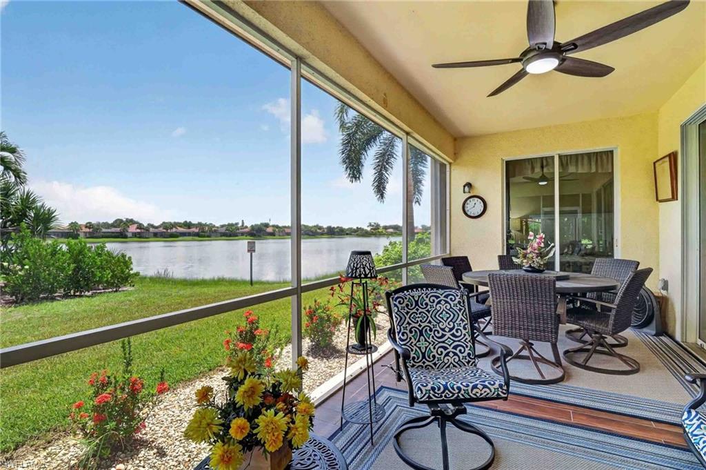 Screened lanai with a ceiling fan, sliding glass doors, and a lakefront setting