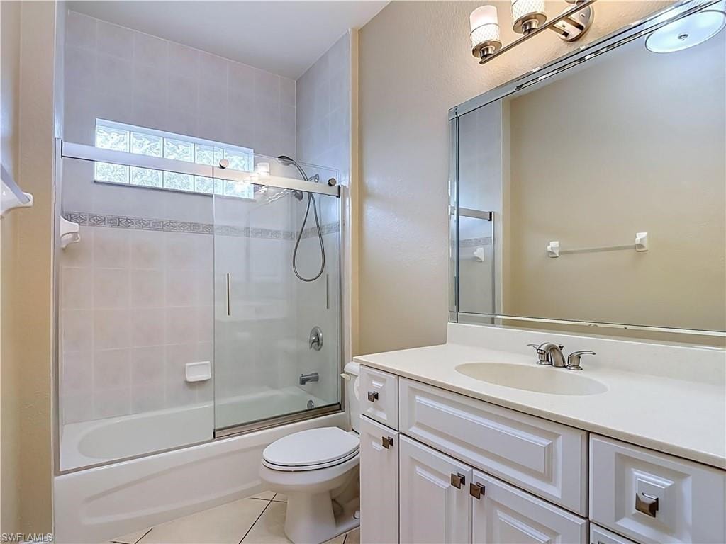 White vanity with integrated sink, brushed nickel faucet, and framed mirror