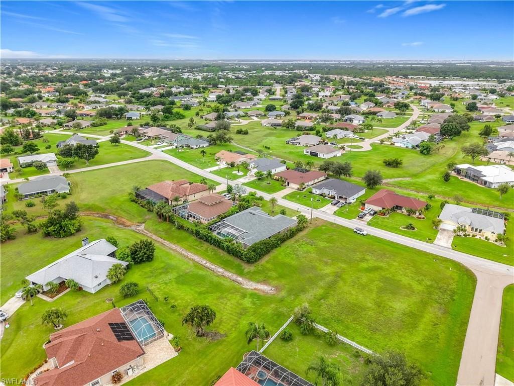 Expansive residential neighborhood featuring single-story homes with various roof styles and a clear sky backdrop