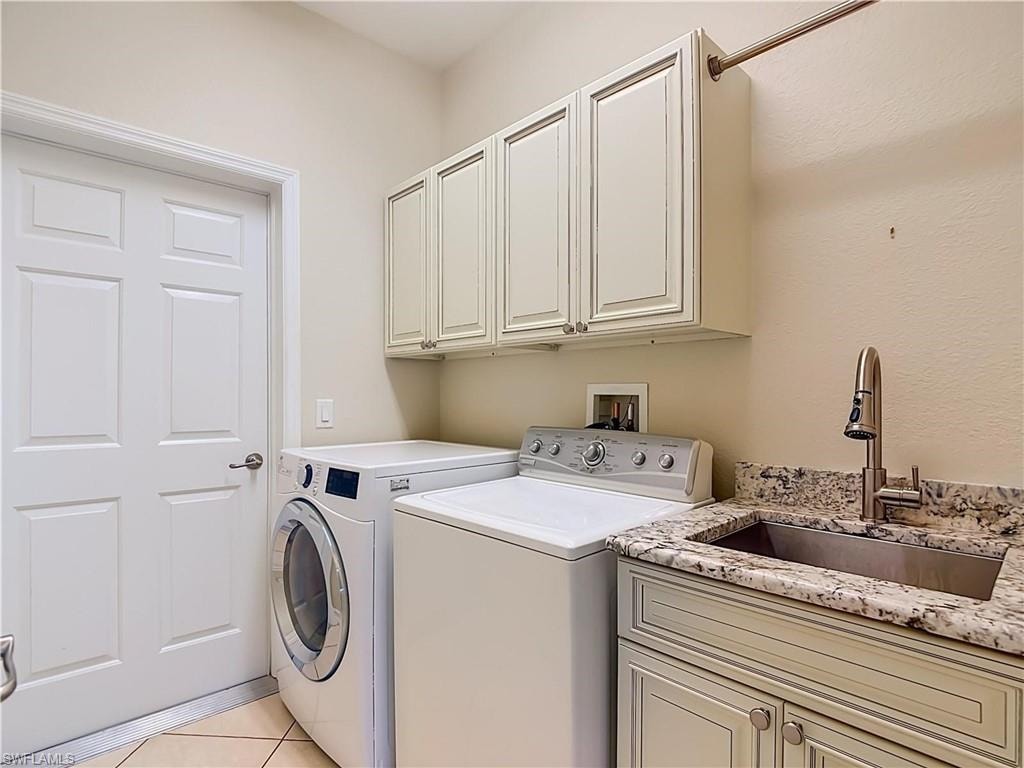 Utility room featuring built-in cabinetry, stone-finish countertops, an undermount sink with a gooseneck faucet, and tile flooring