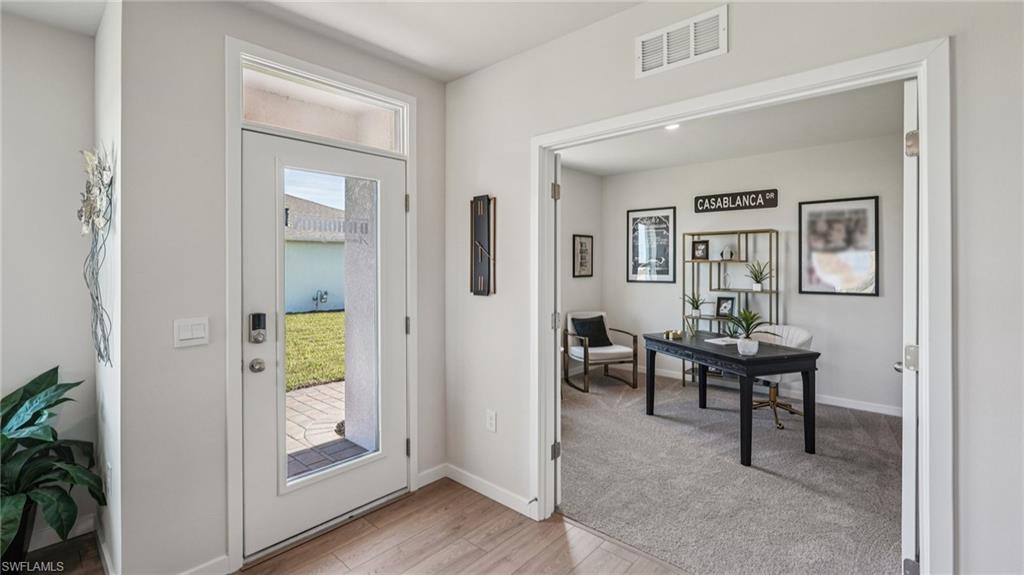 Foyer with wood-finish flooring and a glass-paneled entry door with transom
