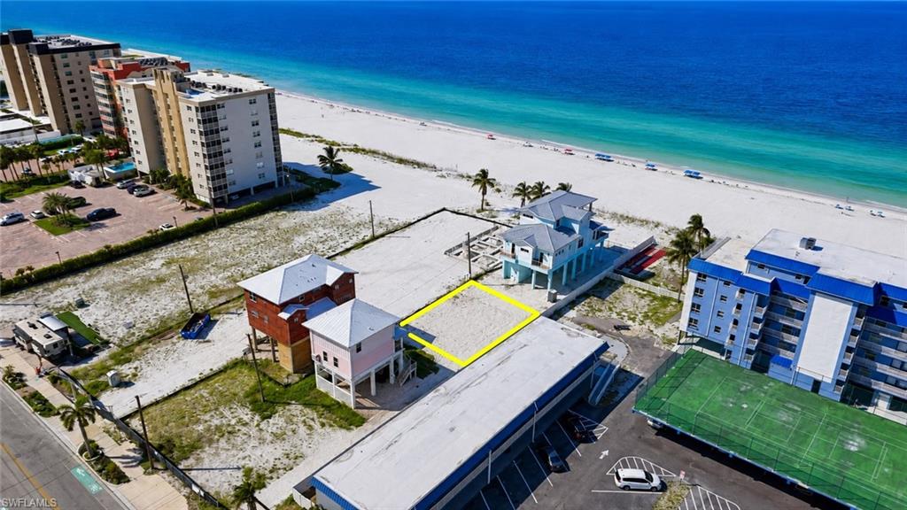 Beachfront parcel with a sandy  - Virtually Edited Imageexpanse, bordered by a paved road, and adjacent to existing coastal structures