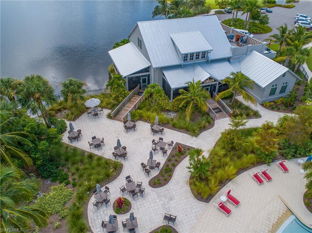 Waterfront building featuring a metal roof, multiple outdoor patio areas with paver surfacing, and established landscaping