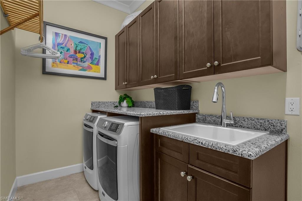 Utility room featuring upper and lower cabinetry, a spacious sink basin with a chrome faucet, and granite-finish countertops