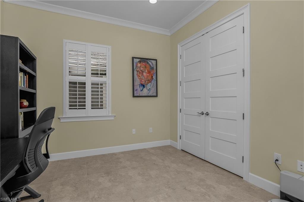 Floor-to-ceiling double doors, plantation shutters, crown molding, and tiled flooring