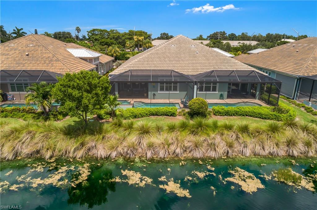 Screened outdoor living area with a pool, tile roof, and waterfront positioning