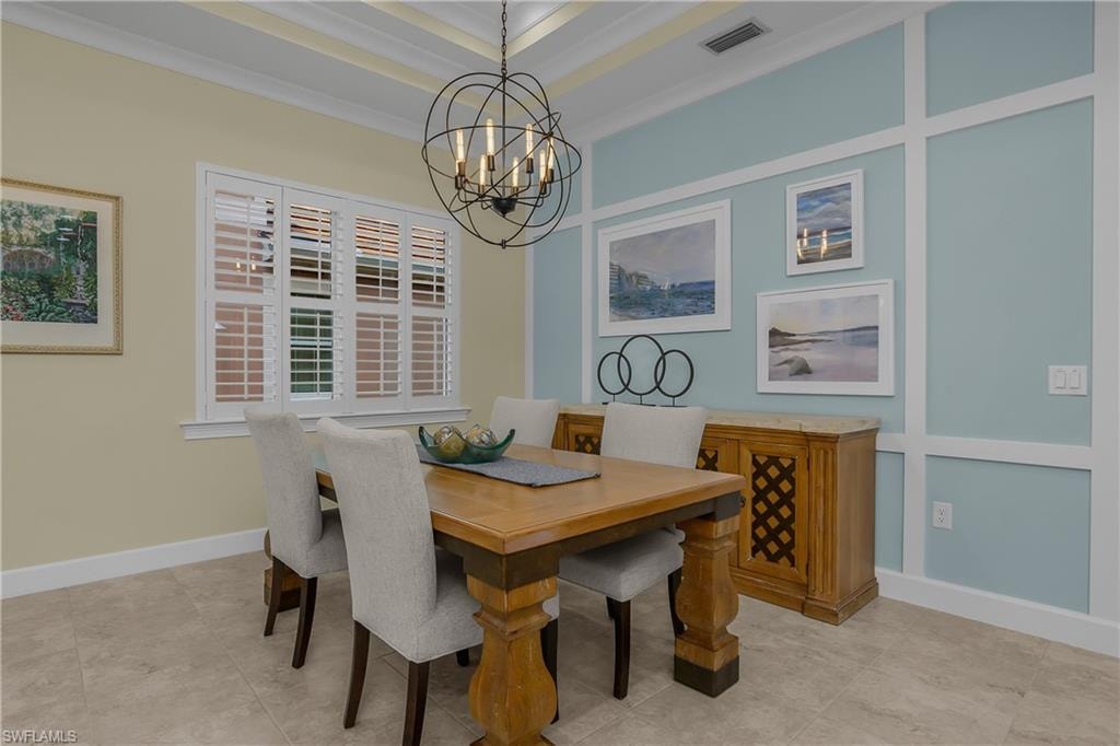Coffered ceiling, decorative wall paneling, window with plantation shutters, tile flooring, and an ornamental chandelier