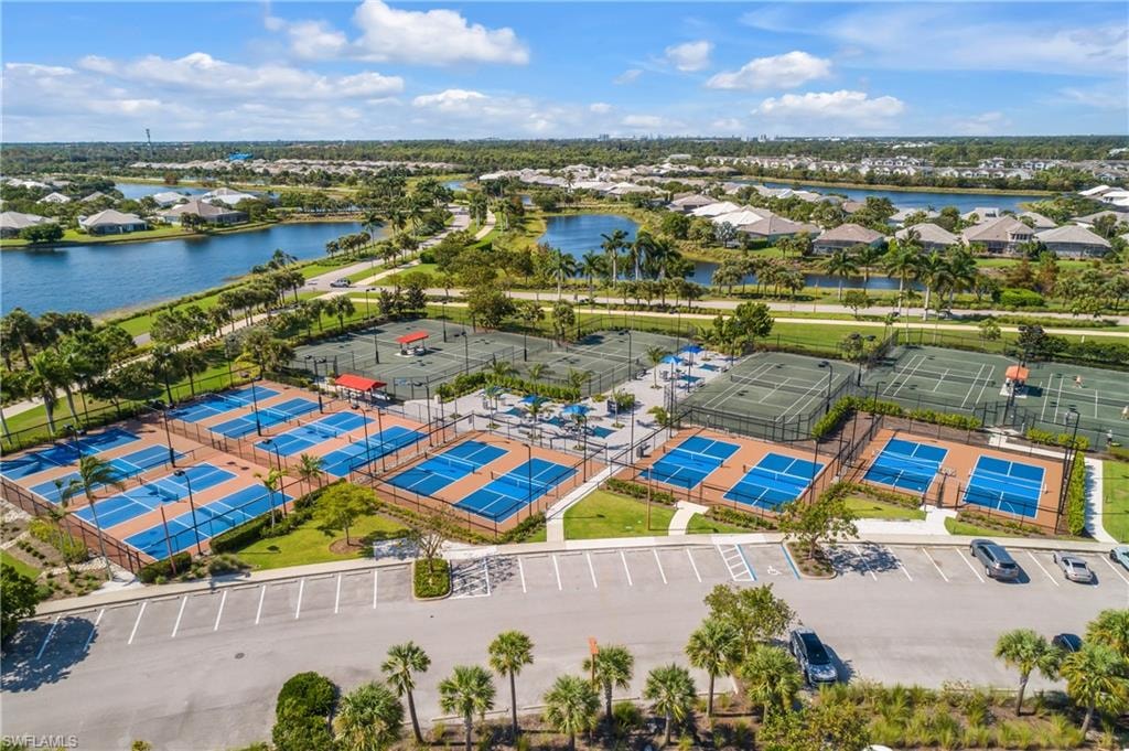 Multiple pickleball courts, tennis courts, and a paved parking area