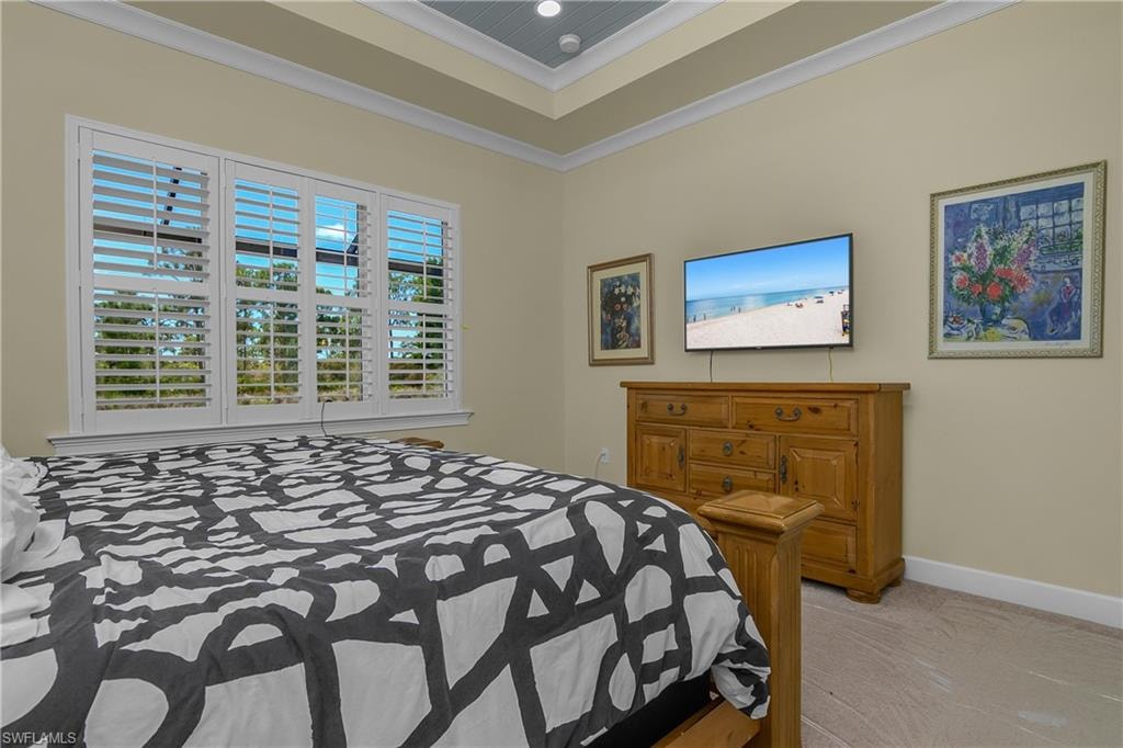 Tray ceiling with recessed lighting, crown molding, plantation shutters, and light-toned wall paint