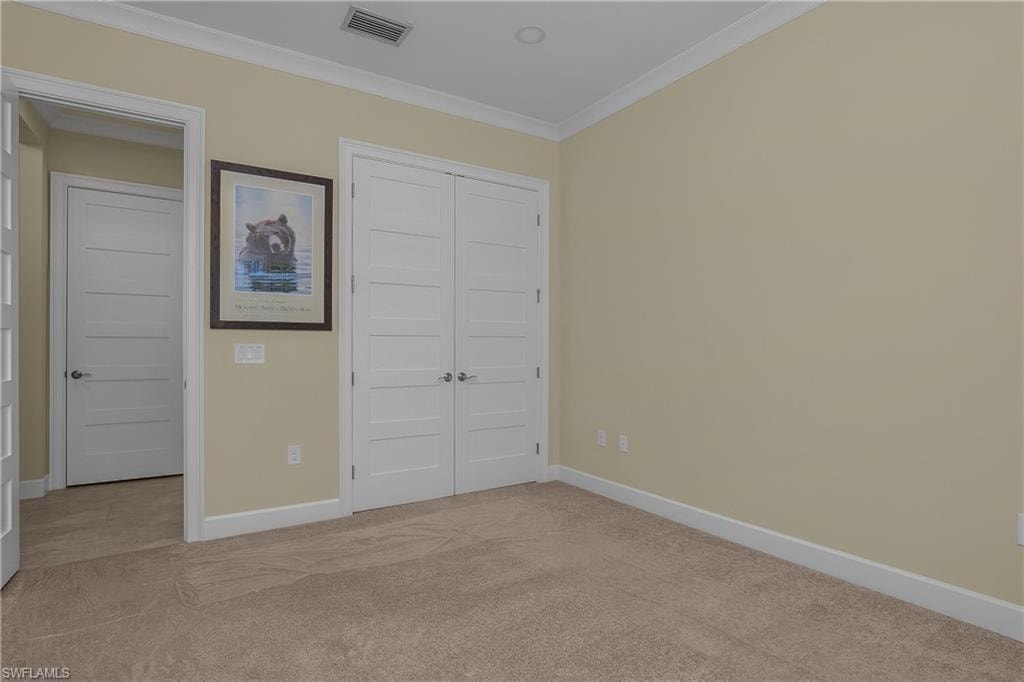Wall-to-wall carpeting with light-colored walls and crown molding