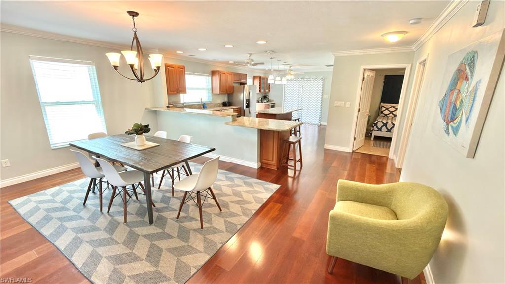 Wood-finish flooring throughout, with a dining area featuring a four-light chandelier.