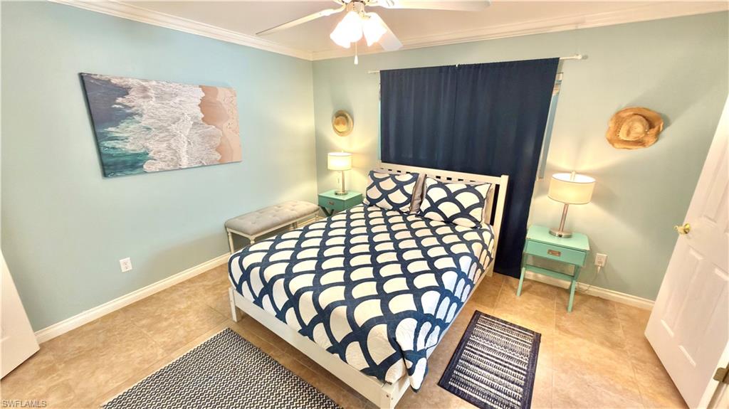 Light blue painted walls with crown molding, ceiling fan, and tile flooring.