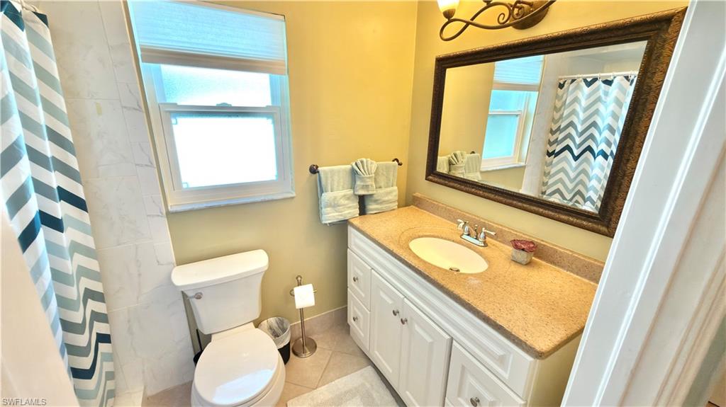 Vanity with an integrated sink, granite-style countertop, and white cabinetry.
