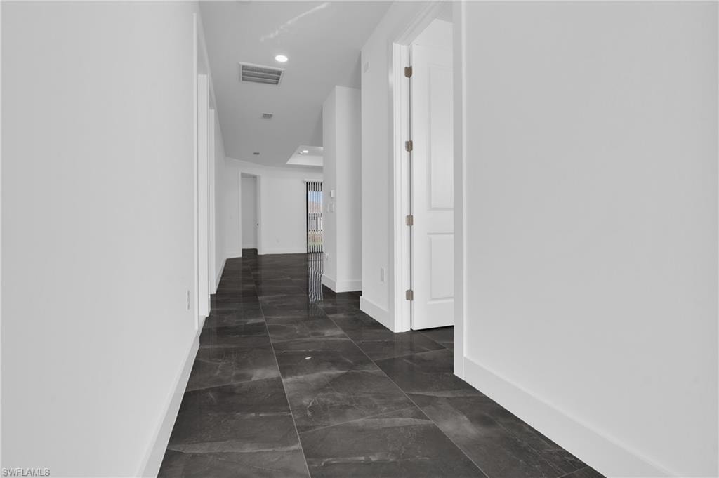 Hallway with baseboards and recessed lighting