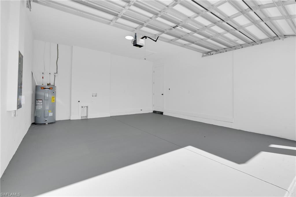 Garage featuring electric water heater and electric panel