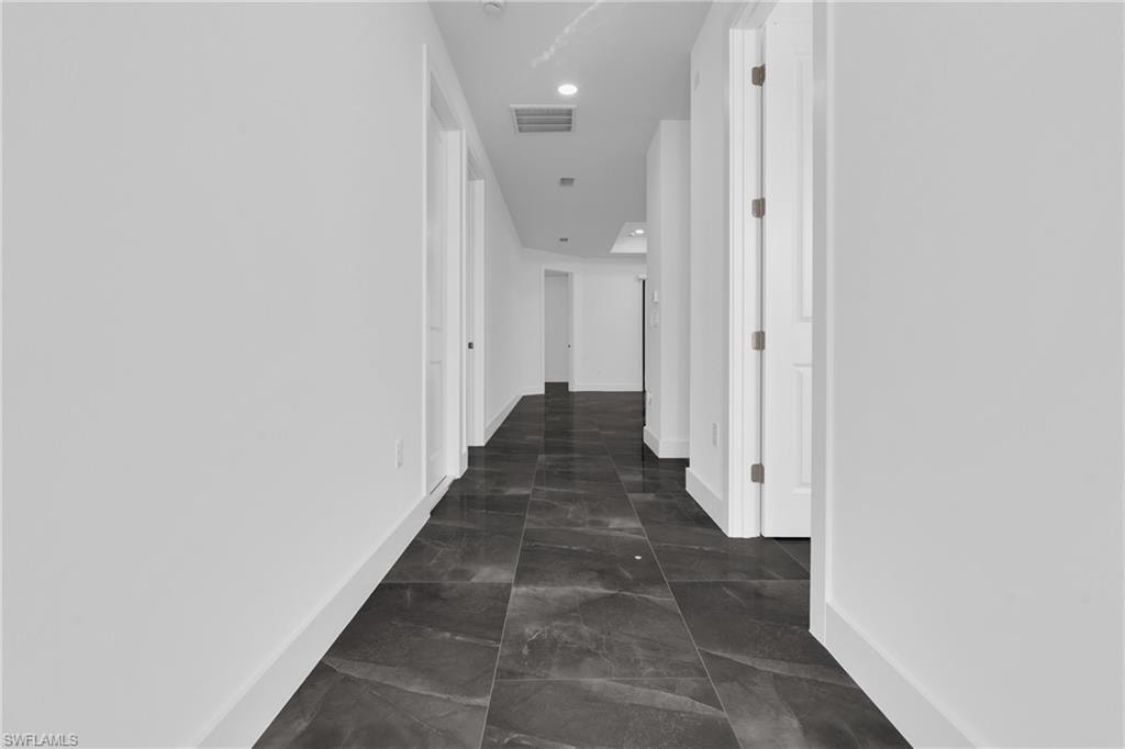Hall with baseboards and recessed lighting