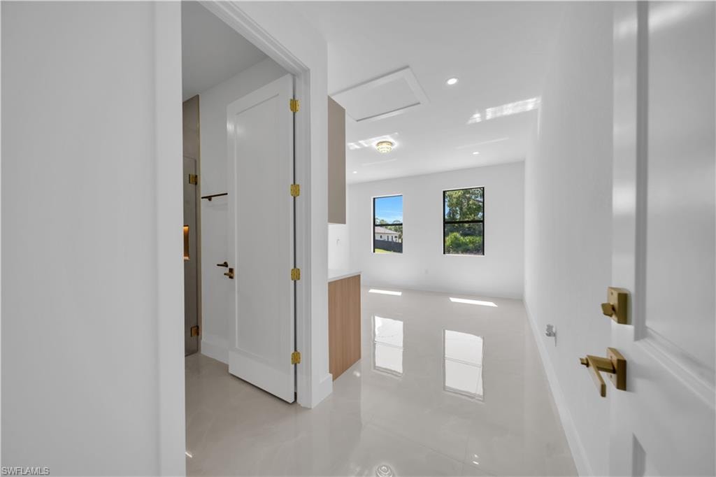 Lustrous tile flooring, white walls, two windows, recessed lighting, and a built-in wood-finish cabinet