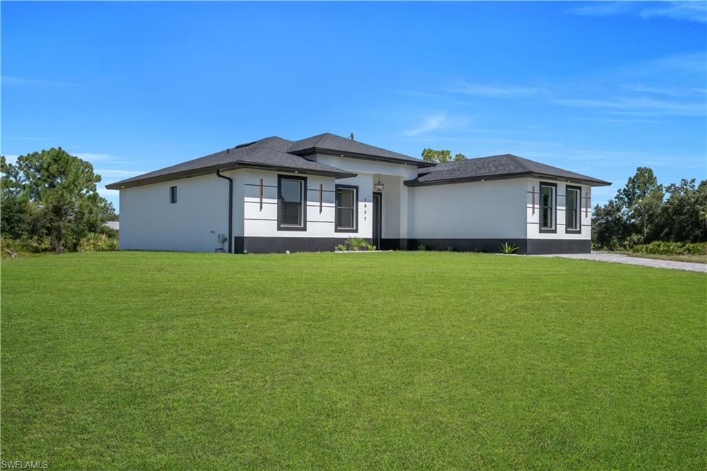 Contemporary architecture with a white stucco exterior, black trim accents, dark-framed windows, and a dark shingle roof