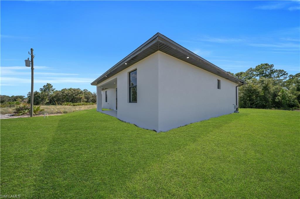 Exterior featuring a white stucco finish, dark framed windows, recessed soffit lighting, and a dark fascia