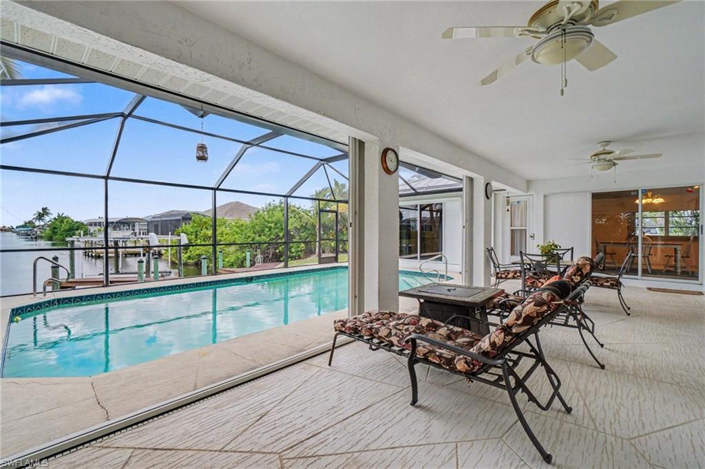 Screened lanai with patterned tile flooring, an integrated swimming pool, and a private dock